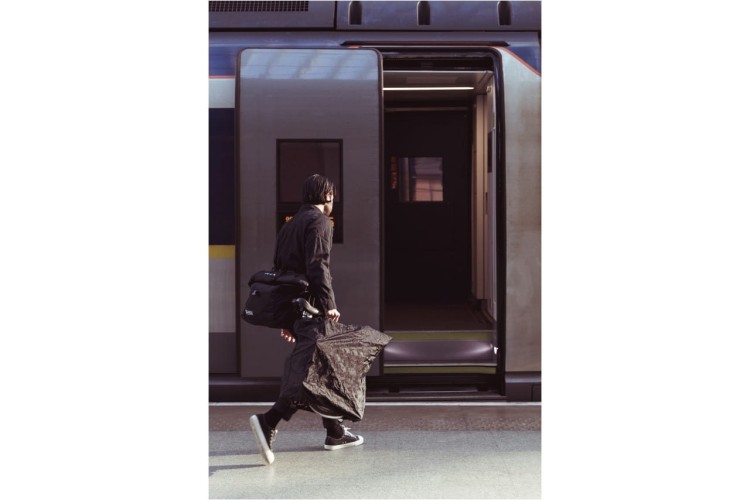 Rowerzysta wsiadający do pociągu z rowerem Brompton w pokrowcu Transit Bike Cover